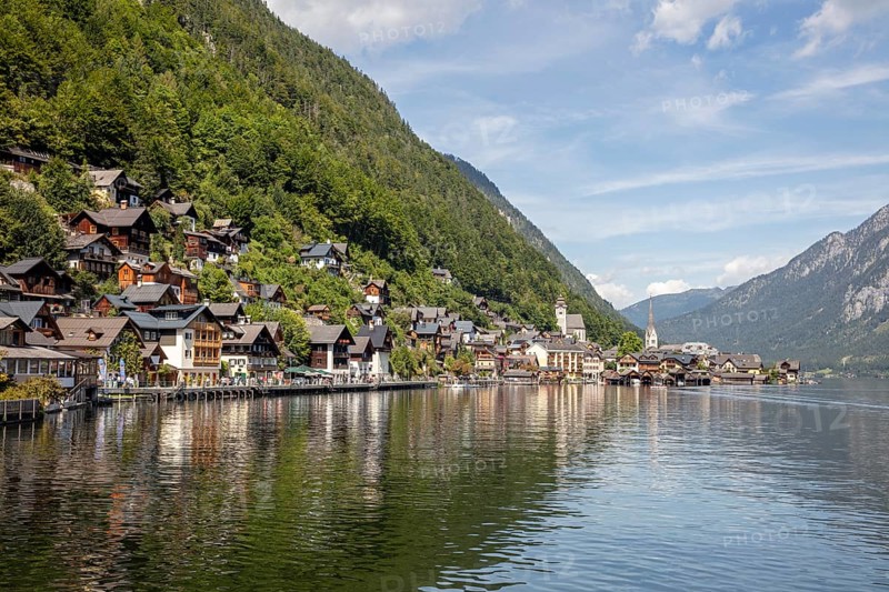 A, Hallstatt, panorama of a picturesque lakeside village with mountains in the background and a church, Austria