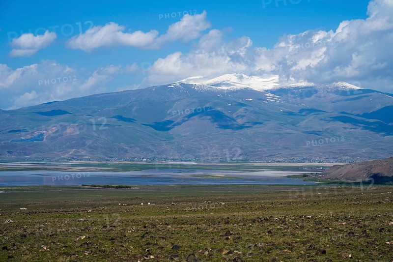 A large lake with snow-capped mountains on the horizon under blue sky, Dogubayazit swamps, wetland near Cevirme, Dogubayazit, Dogubeyazit, Agri Province, Agri, Eastern Anatolia, Anatolia, Turkey