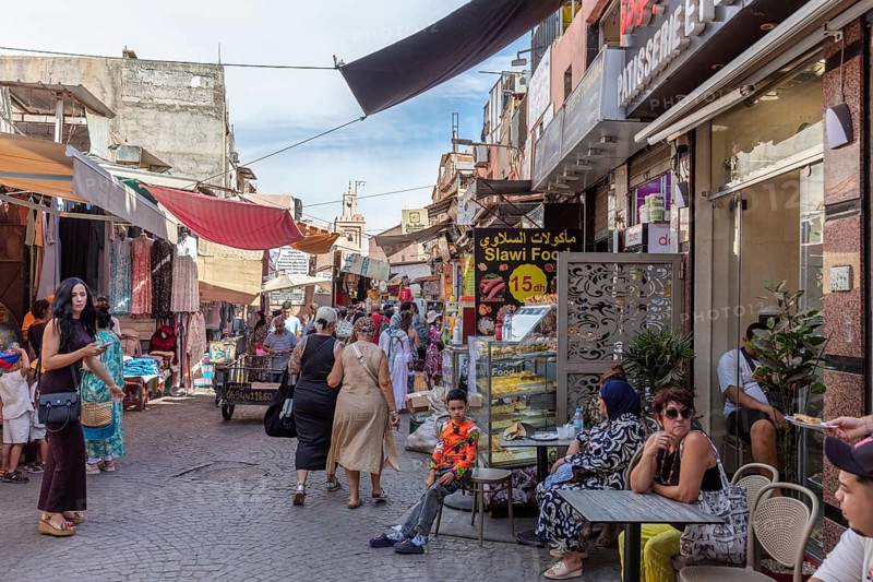 Lively street full of people with street cafés and shops, relaxed hustle and bustle