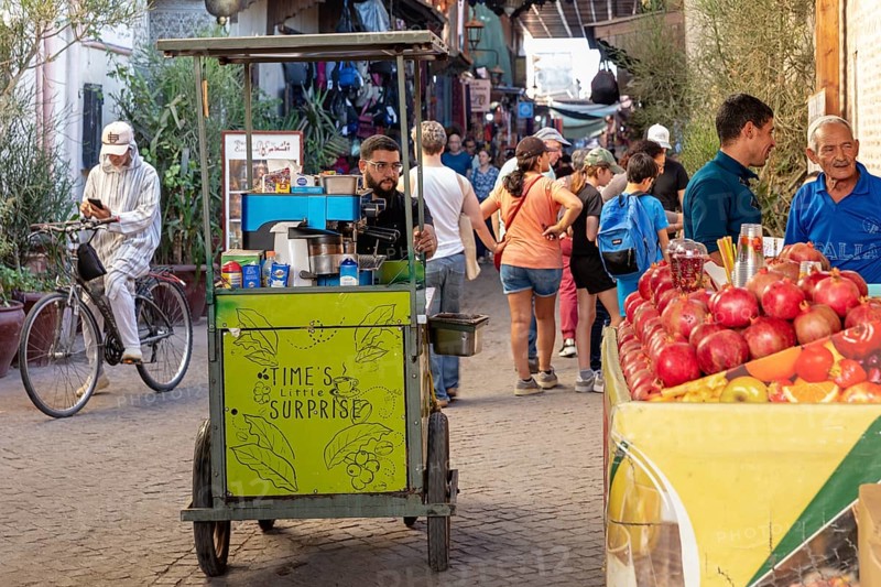 Street stand with fruit and a vendor on a busy street