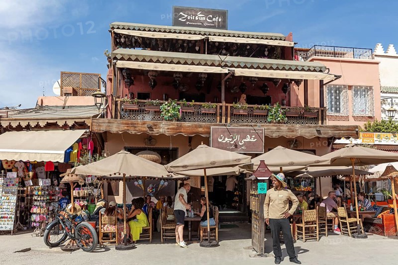 A café with a terrace where people sit and relax under umbrellas