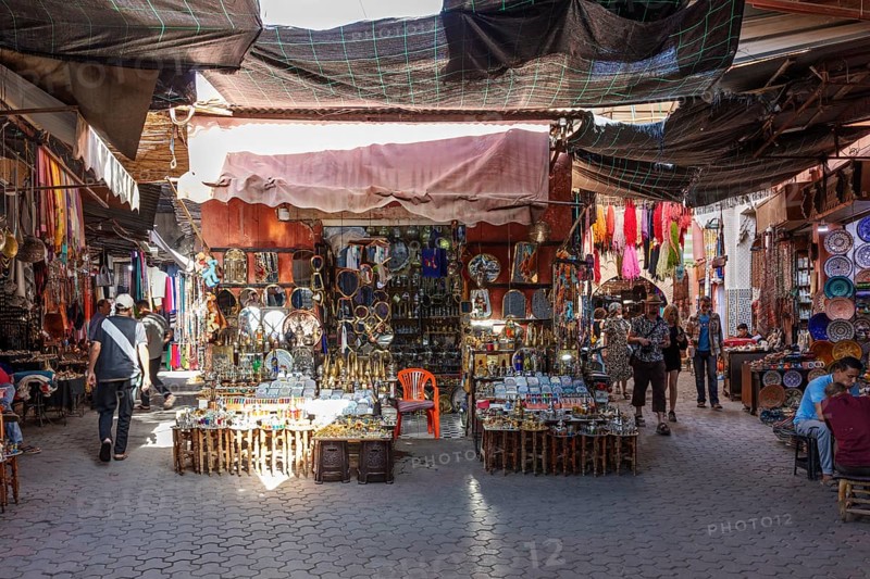 Market scene in Morocco with numerous souvenir stands and colorful cloths