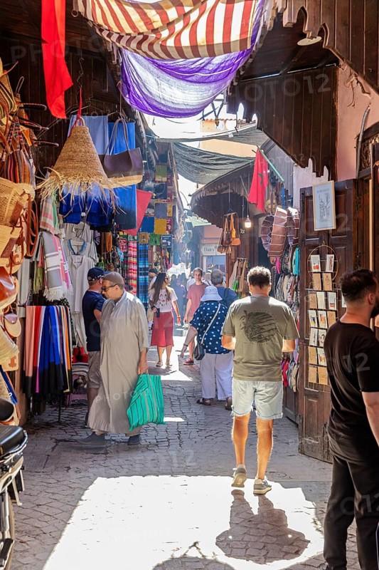 Colourful market with fabrics and lamps, full of people and lively hustle and bustle