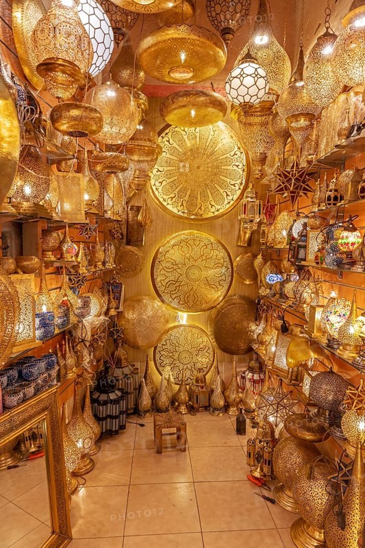 A room with numerous golden, artfully designed Moroccan lamps