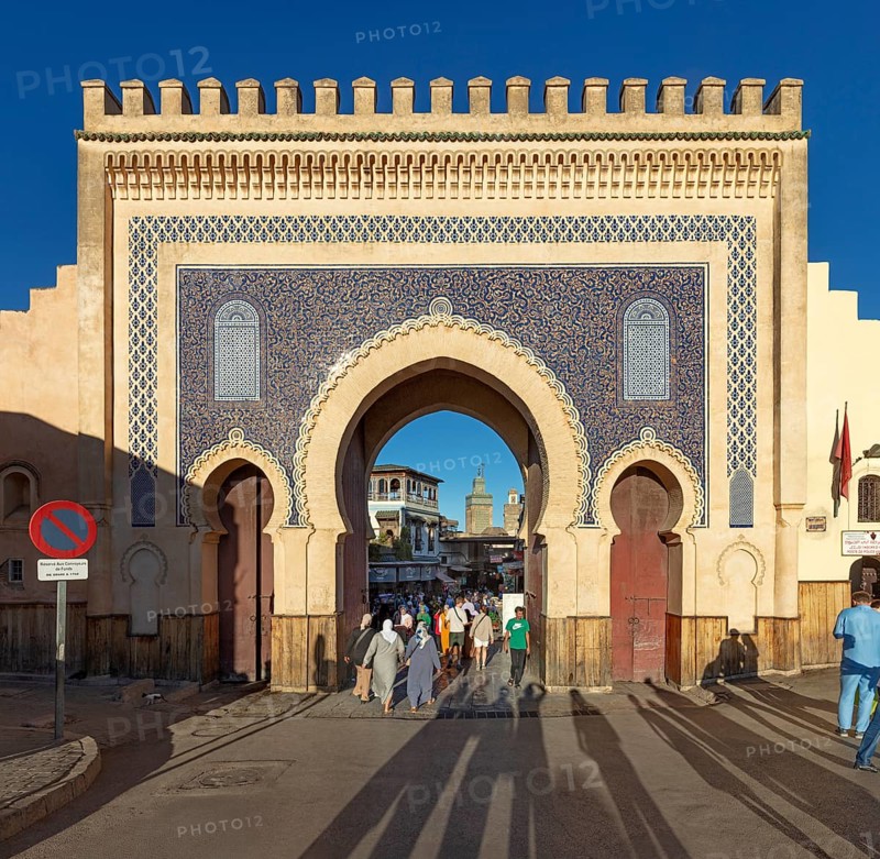 Large traditional gate with blue mosaic and people walking through