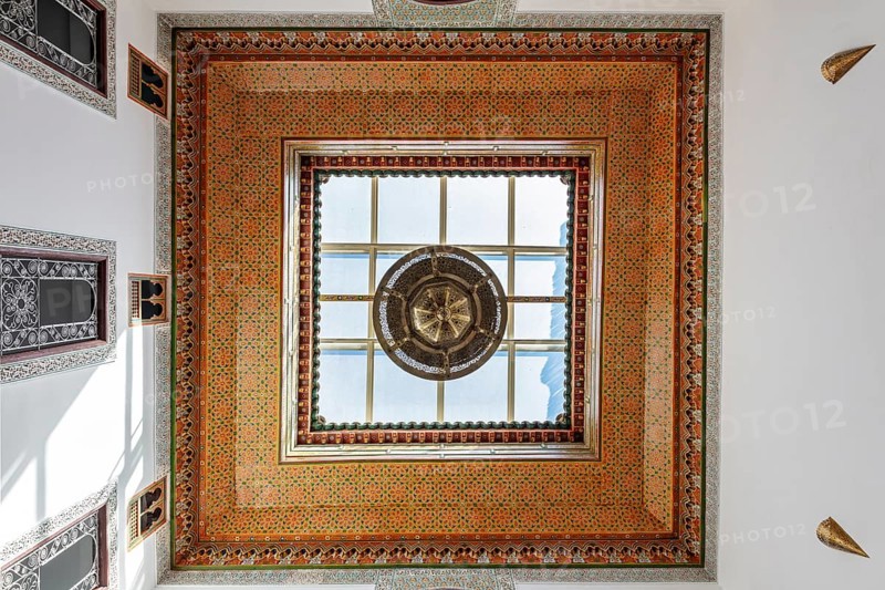 Ornately decorated ceiling with colorful mosaics and a large window