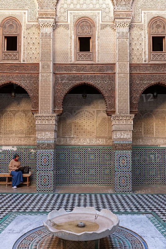 Traditional courtyard with ornate mosaics, round arches and a small fountain