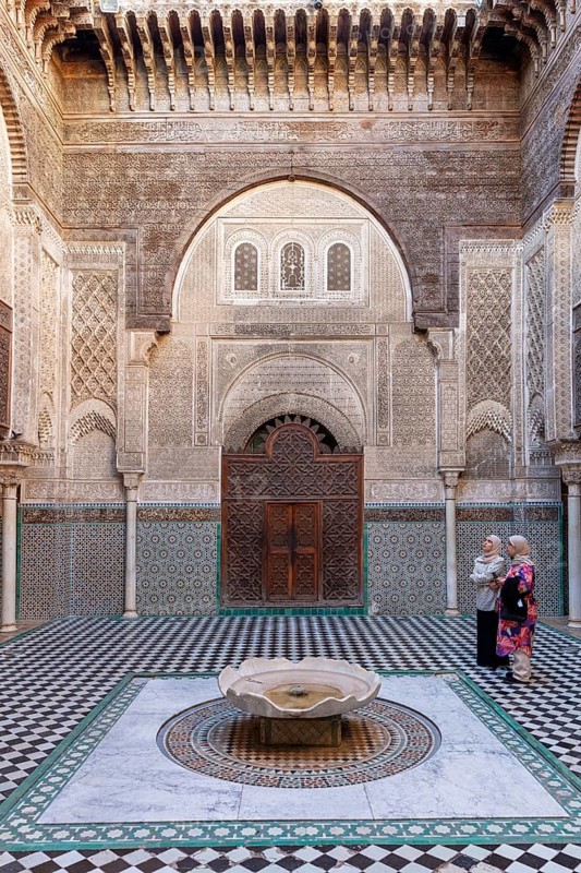 Traditional courtyard with ornate mosaics and a central water fountain