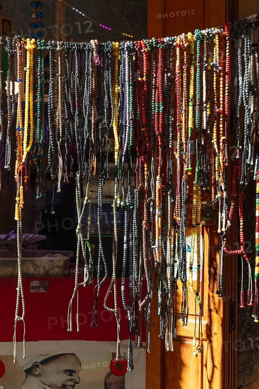 A variety of colorful chains hang on a shop door in an artisan shop