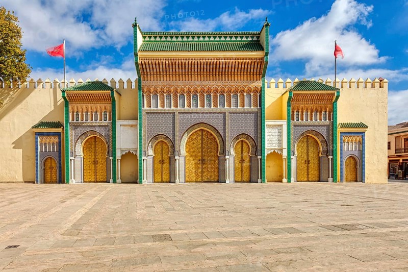 Detailed view of an ornate palace entrance with colorful mosaics and arches