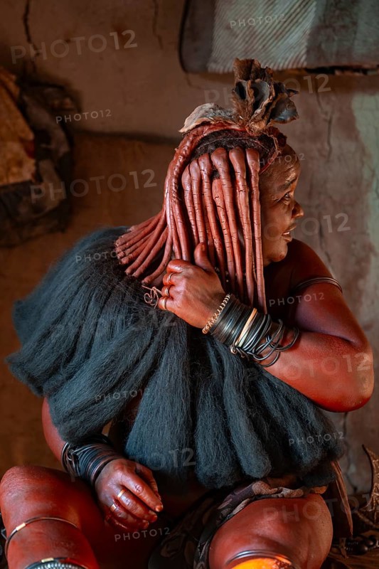 Elderly Himba woman showing her hair and jewelry, in a hut, traditional Himba village, Kaokoveld, Kunene, Namibia