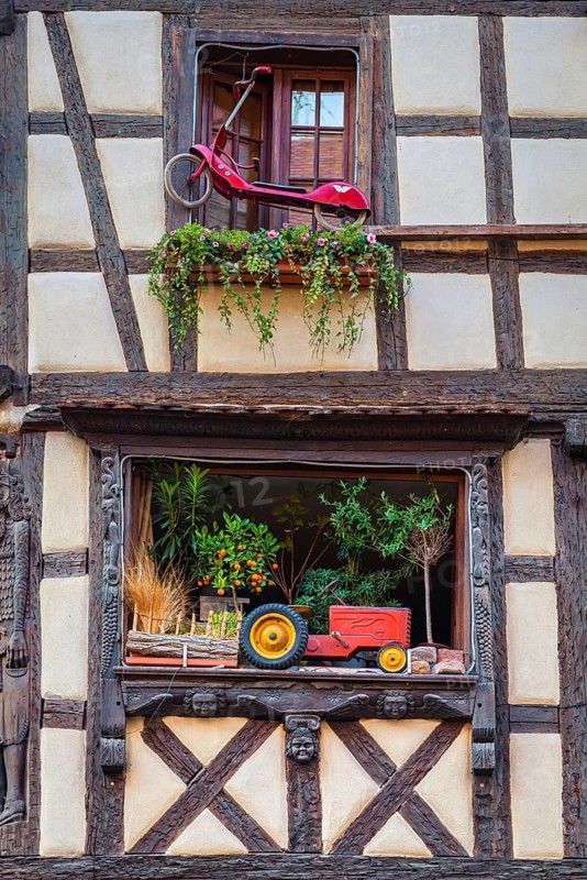 Timber-frame house decorated with vehicles in the historic old town of Riquewihr, Ellsass