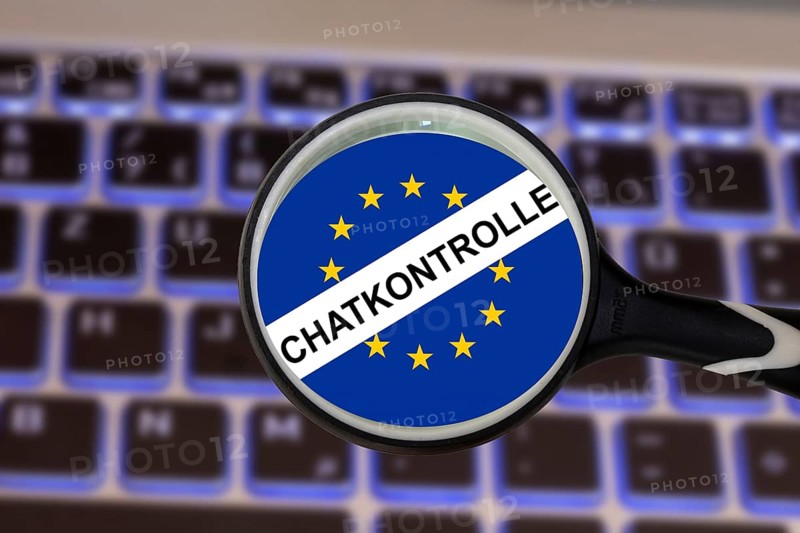 (photo montage) Magnifying glass shows the EU flag and the word CHAT CONTROL, with laptop keyboard in the background