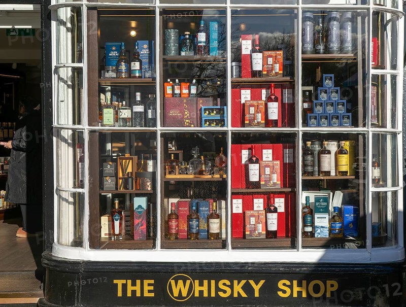 Shopfront window display The Whisky Shop store, Cathedral Close, Exeter city centre, Devon, England, UK