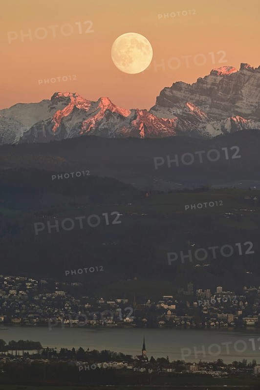 View from Horben of Lake Zug with the town of Cham and Zug, behind it the snow-capped mountains Flübrig and Vrenelisgärtli, in the light of a full moon, Beinwil-Freiamt, Canton, Aargau, Switzerland