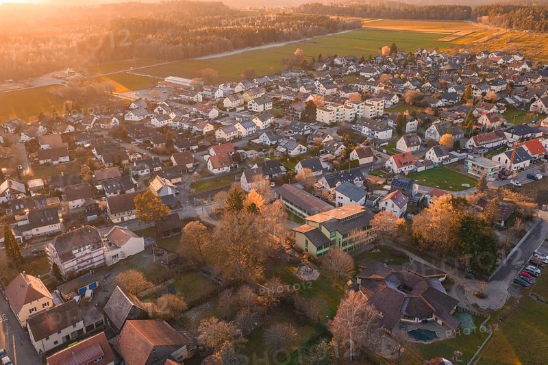 Village seen from the air in autumn twilight with surrounding fields, Althengstett, Calw district, Germany