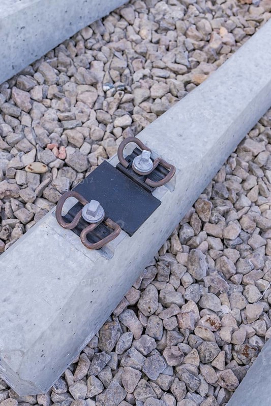 Close-up of a concrete threshold with fasteners on gravel, track construction of the Hermann Hesse Railway, Calw, Germany