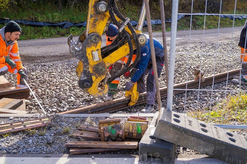 Construction workers install rails on a construction site with heavy equipment, Hermann Hesse Railway track construction, Calw, Germany