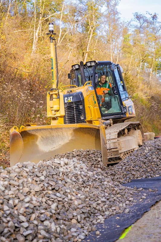 Bulldozer with a large shovel moves gravel on a construction site, track construction of the Hermann Hesse Railway, Calw, Germany