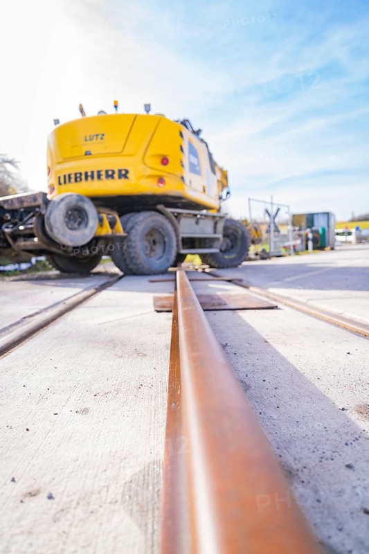 LIEBHERR excavator near rails, blue sky perspective, track preparation, Hermann Hesse Railway track construction, Calw, Germany