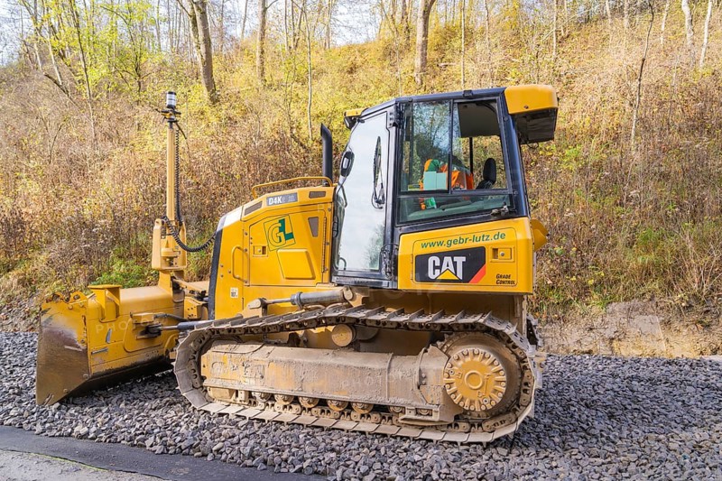 CAT chain tractor on gravel, autumn vegetation during construction work in the background, Hermann Hesse Railway track construction, Calw, Germany