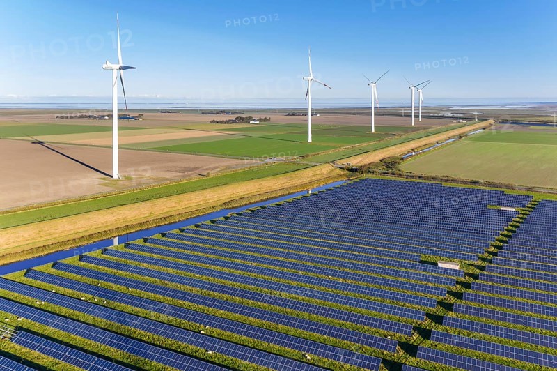 Aerial view over hybrid power plant combing solar photovoltaic modules and wind turbines, North Frisia, Schleswig-Holstein, Germany