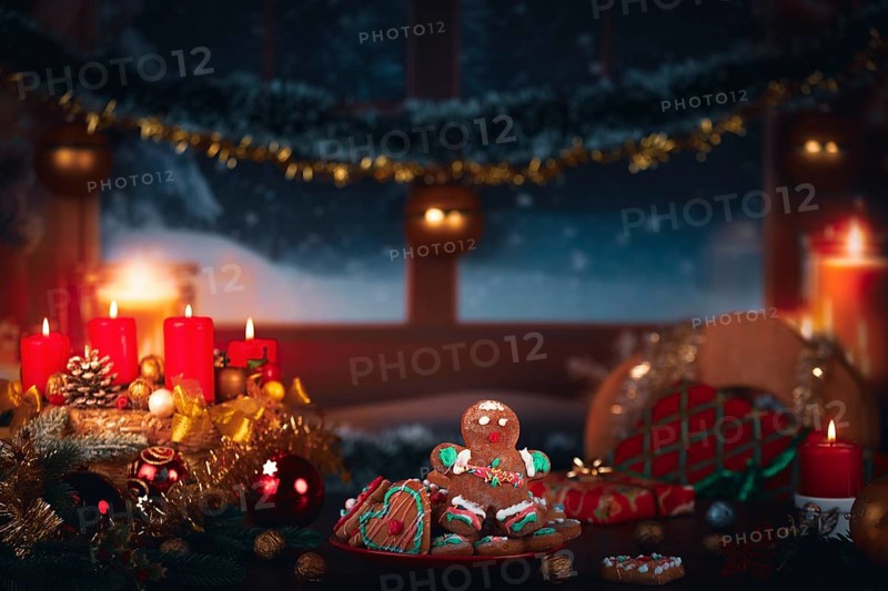 Winter scene with candles, gingerbread man, gifts and Christmas decoration