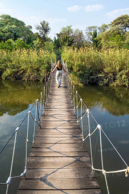Toruist on the Kavango River, suspension bridge at Camp Kwando, Zambezi region, Caprivi Strip, Namibia
