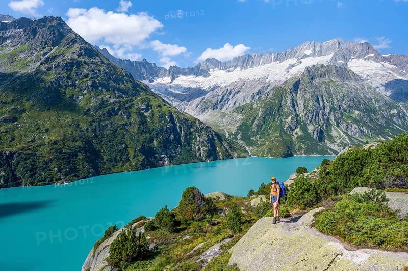 Female mountaineer in front of picturesque mountain landscape, turquoise-blue mountain lake Göscheneralpsee, Dammastock and Damma glacier, Göscheneralp, Canton of Uri, Switzerland