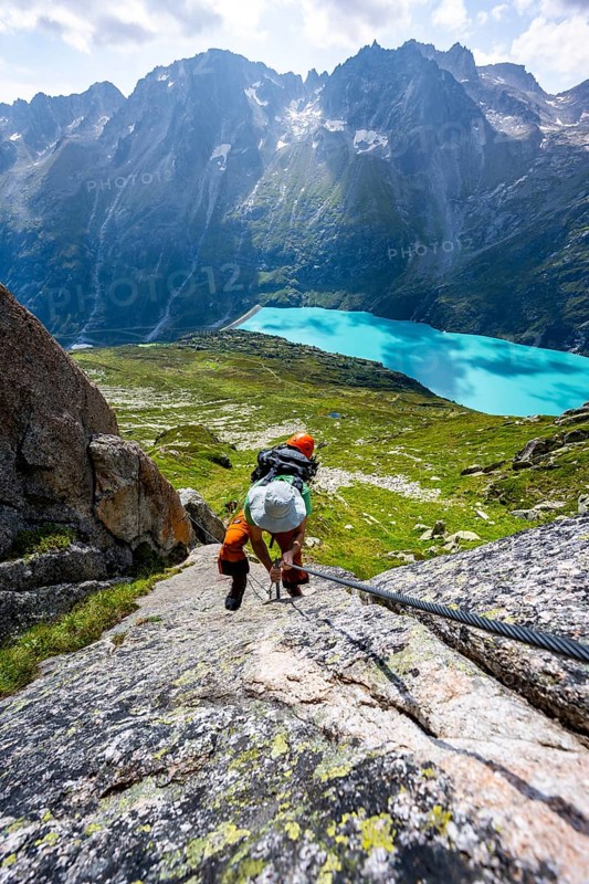 Mountaineer climbs on the secured Schijen-Zwärg via ferrata, climb to Bergseehütte, Göscheneralp in the back, Canton of Uri, Switzerland