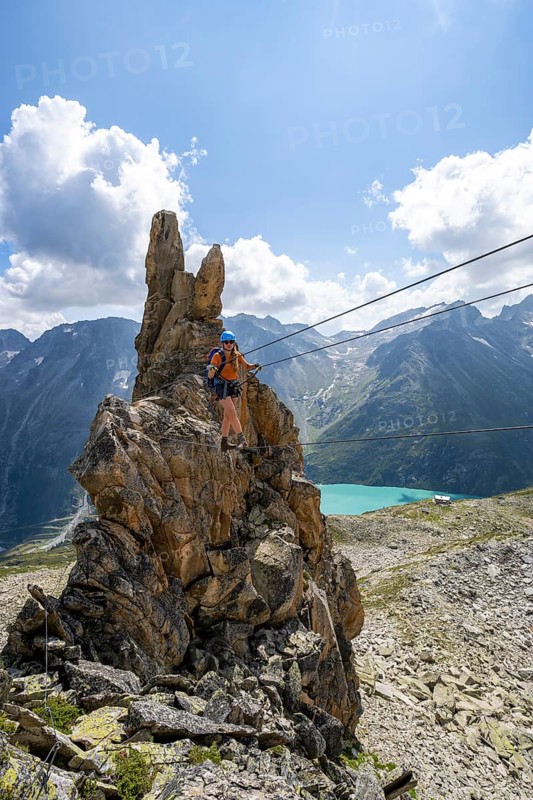Crocodile rock formation, mountaineer on rope bridge in the Crocodile Mountain Lake via ferrata on Bergseeschijen-Vorbau, Göscheneralp, Canton of Uri, Switzerland