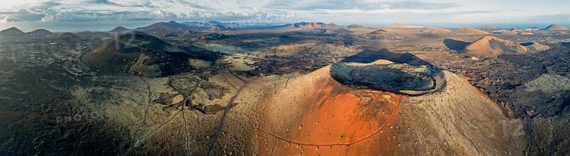 Caldera Colorada volcano and Montaña Negra, picturesque volcanic landscape with volcanic craters and lava fields in morning light, Parque Natural de Los Volcanes, aerial view, Lanzarote, Canary Islands, Spain