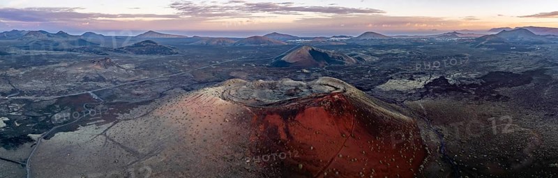 Caldera Colorada volcano, picturesque volcanic landscape with volcanic craters at sunrise, Los Volcanes Natural Park, aerial view, Lanzarote, Canary Islands, Spain