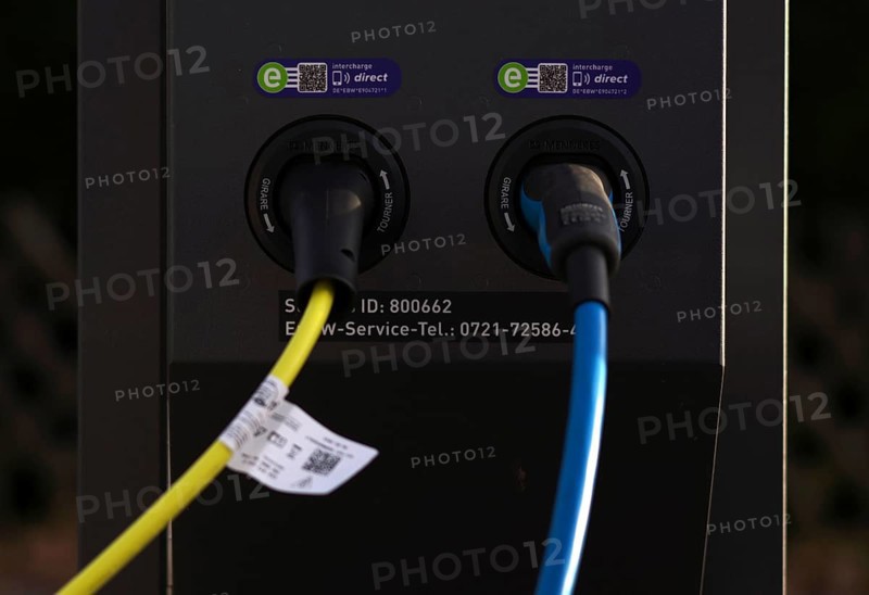 Detailed view, parking lot with gas pump, EnBW charging station for electric cars, charging station, e-charging station, e-mobility, charging cable leading into two vehicles, Stuttgart, Baden-Württemberg, Germany