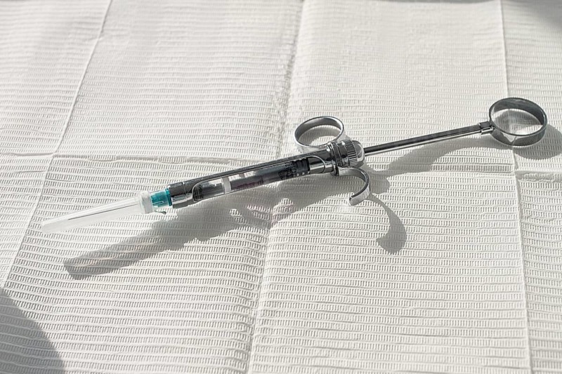 A carpal syringe, reusable, for use in dentistry, for the administration of anesthetic, lies on the table