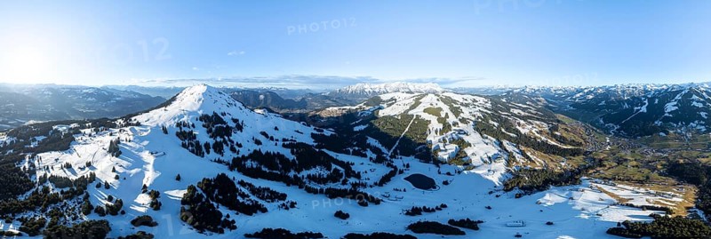 Wonderful winter landscape with Hohe Salve, blue sky and snow, mountains and mountain valley, aerial view of Skiwelt Wilder Kaiser ski area, Brixental, Tyrol, Austria