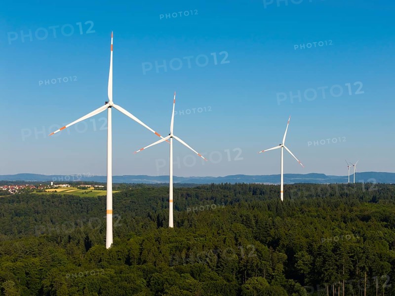 Several wind turbines stretch into the sky over an extensive forest area, near Schorndorf, Remstal, Baden-Württemberg, Germany