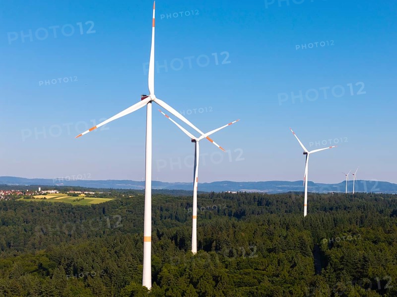 Wind turbines tower over a wooded landscape, dominated by clear skies, near Schorndorf, Remstal, Baden-Württemberg, Germany