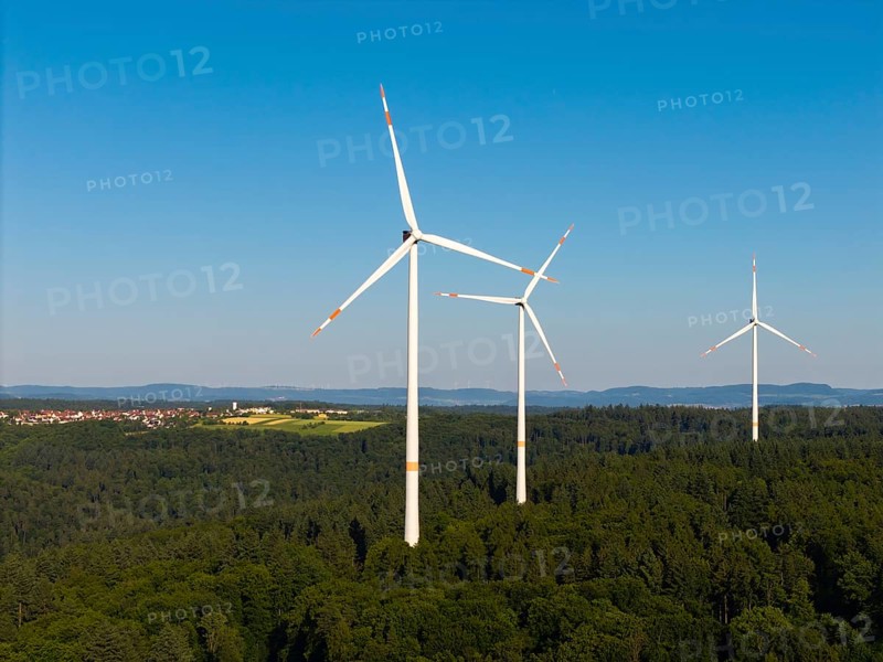 Three wind turbines above a dense forest area under a clear sky, near Schorndorf, Remstal, Baden-Württemberg, Germany