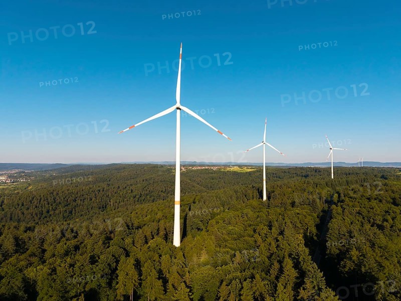 Wind turbines over dense forest stretch into the vastness of the sky, near Schorndorf, Remstal, Baden-Württemberg, Germany