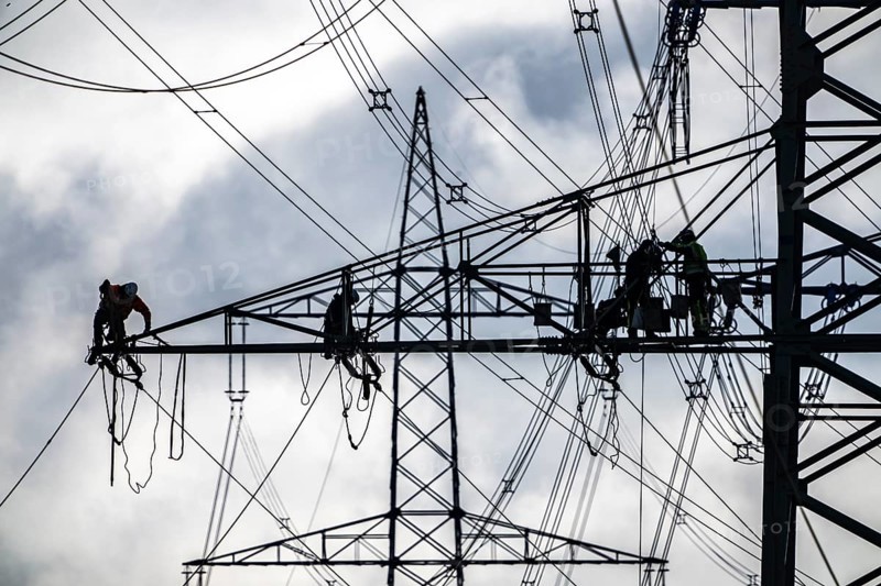 Work on a 380 kV high-voltage overhead line, new construction, along the A57 motorway, near Meerbusch, workers on the boom of the high-voltage pylon, North Rhine-Westphalia, Germany