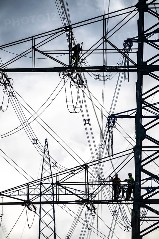 Work on a 380 kV high-voltage overhead line, new construction, along the A57 motorway, near Meerbusch, workers on the boom of the high-voltage pylon, North Rhine-Westphalia, Germany