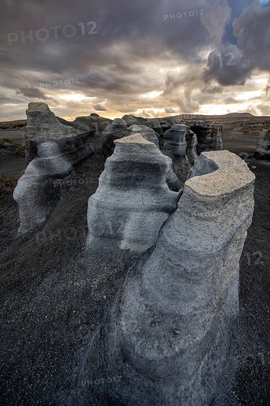 Eroded rock formations, volcanic landscape with dramatic cloudy sky at sunset, Ciudad Estratificada or Los Roferos, Antigua Rofera de Teseguite, Lanzarote, Canary Islands, Spain