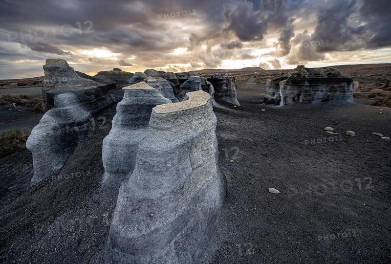 Eroded rock formations, volcanic landscape with dramatic cloudy sky at sunset, Ciudad Estratificada or Los Roferos, Antigua Rofera de Teseguite, Lanzarote, Canary Islands, Spain