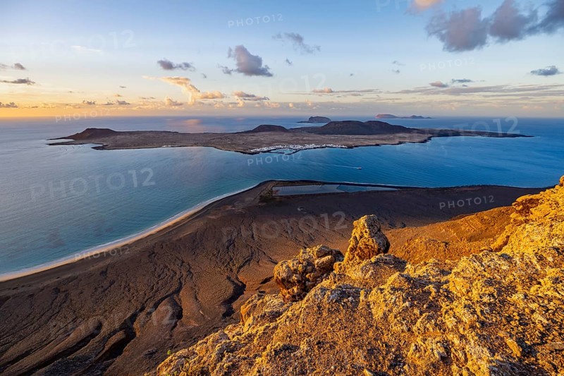 View of steep cliffs to sea and the island of La Graciosa, Mirador del Porrito viewpoint at sunset, Lanzarote, Canary Islands, Spain