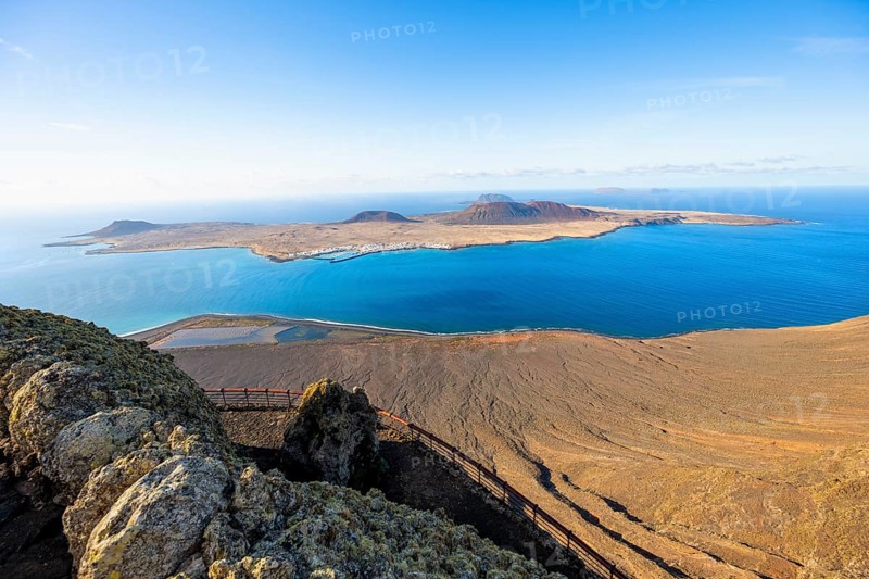 View of La Graciosa island with volcanic craters in the evening light, Mirador del Río viewpoint designed by artist César Manrique, Lanzarote, Canary Islands, Spain