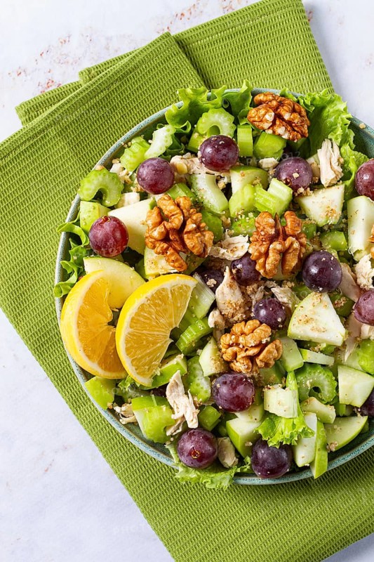 Fresh Waldorf salad, celery stalk with chicken, apple and walnuts, grapes, herbs, homemade, without people