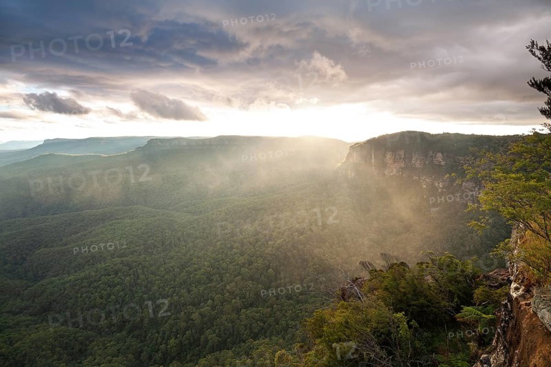 Evening sky with clouds of fog and setting sun at the Three Sisters at Echo Point in Katoomba, Blue Mountains, New South Wales, Australia