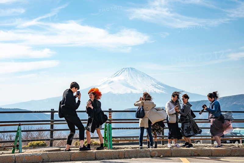 Tourists enjoy the view and take pictures, view of the snow-covered summit of Mount Fuji volcano in spring, Owakudani, Hakone, Japan