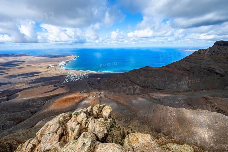 View from the Risco de Famara cliffs to the coast and the sea with the Famara beach, Playa de Famara, Lanzarote, Canary Islands, Spain